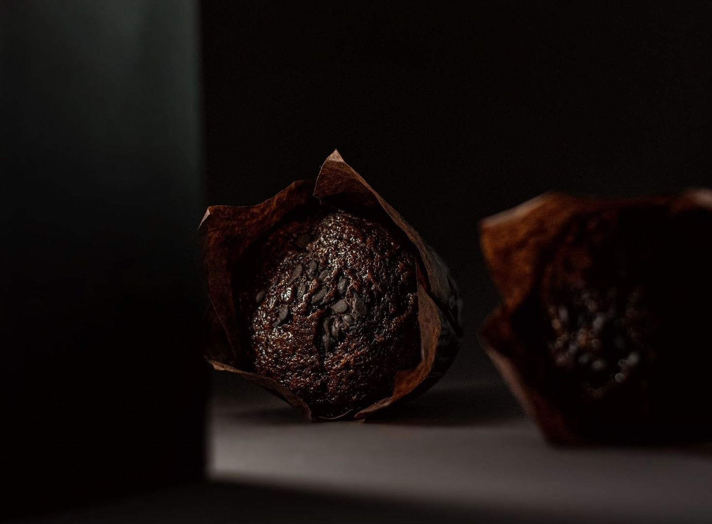 Donkere chocolademuffins in dramatisch clair-obscurlicht